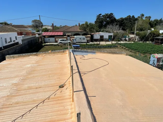 Cubiertas de fibrocemento de una vivienda con huerto, aisladas con poliuretano proyectado
