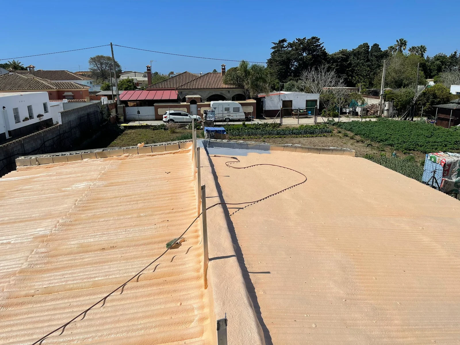 Cubiertas de fibrocemento de una vivienda con huerto, aisladas con poliuretano proyectado