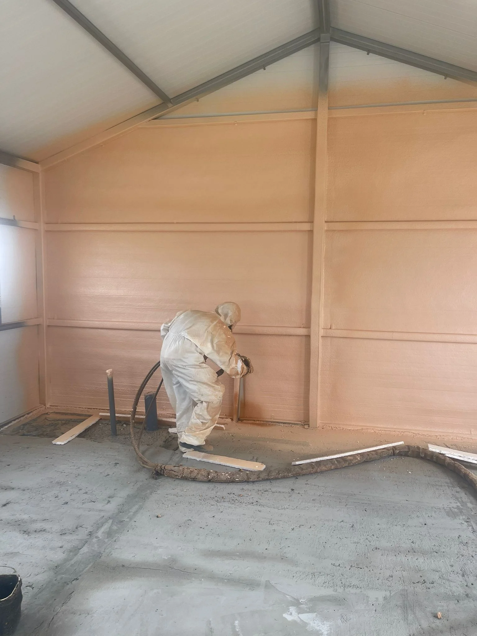 Interior de una nave con las paredes aisladas con poliuretano proyectado hasta la cubierta