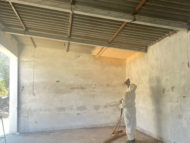 Proyección de poliuretano por el interior, bajo una cubierta de fibrocemento